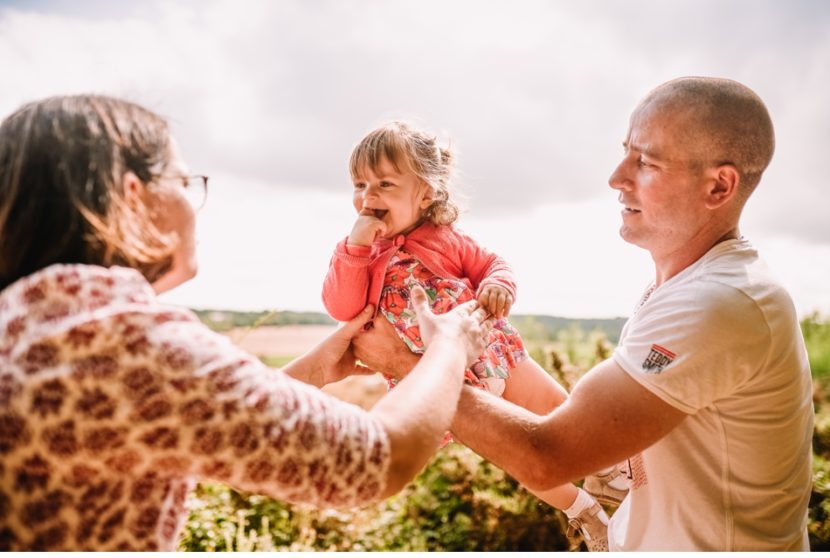 bébé dans les bras de papa et maman